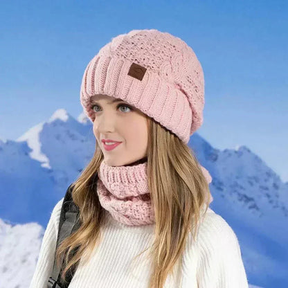 Woman wearing pink Glorious™ Winter Glow Duo knit hat and scarf set in snowy mountain background